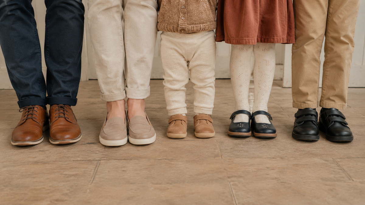 a family stood next to each other. The focus is on the shoes each of them are wearing.